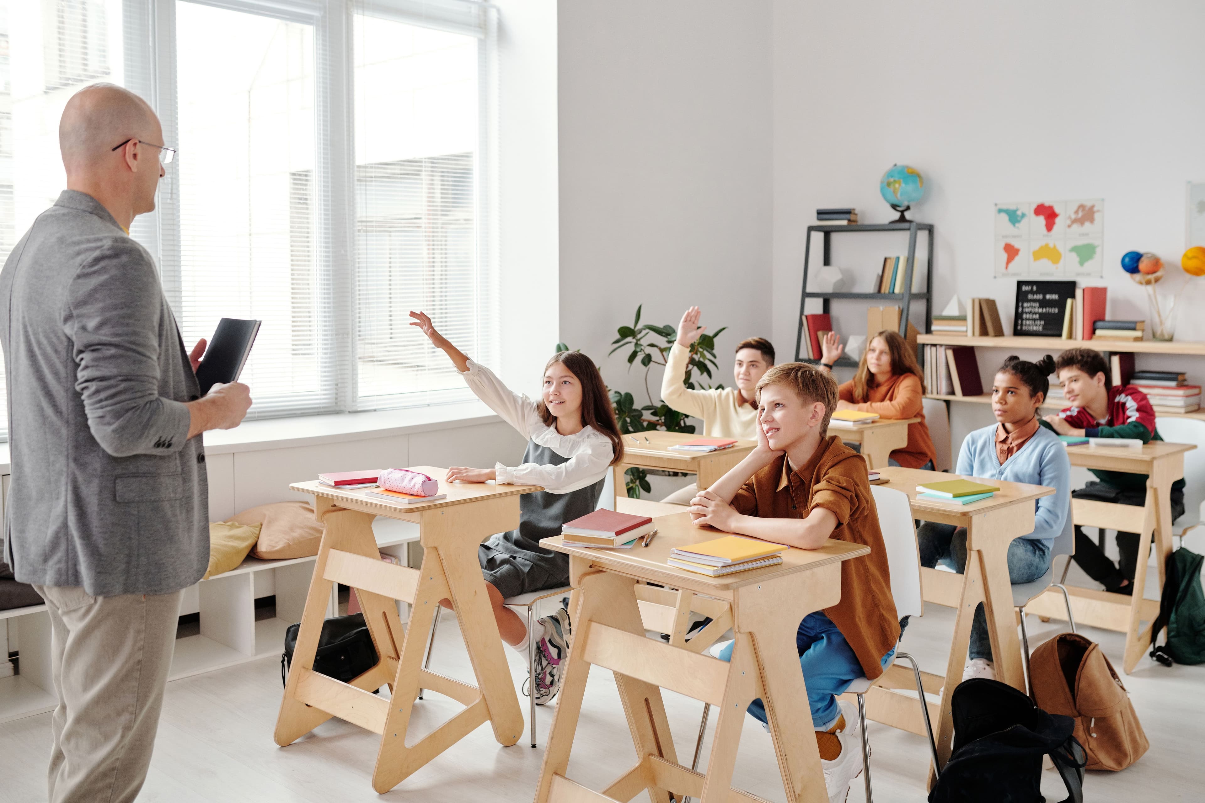 Students engaged in class, hands raised