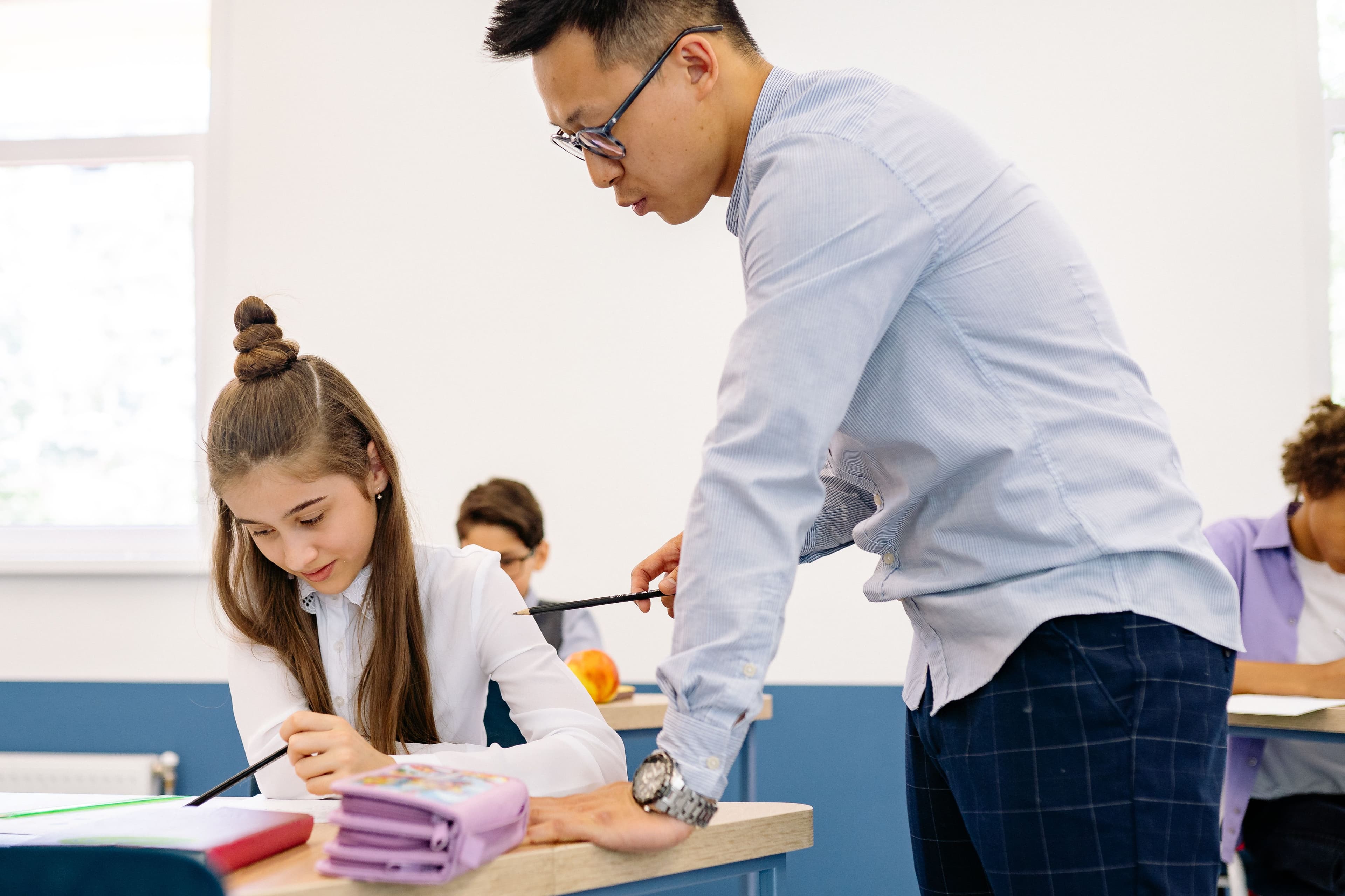 Teacher helping a student at their desk